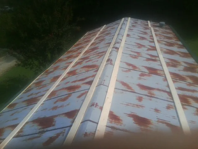 Rusted metal roof panels with new wood purlins before replacement — Storm Damage Roof Repair in Provincetown by Roofing Brothers